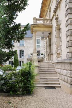 Ancient building with marble stairs, balcony and porch in Chantilly, Oise, France