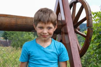 Smiling boy in front of old style wooden well