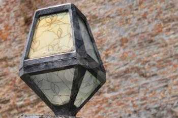 Original lantern in retro style on brick wall background. Mukachevo, Ukraine