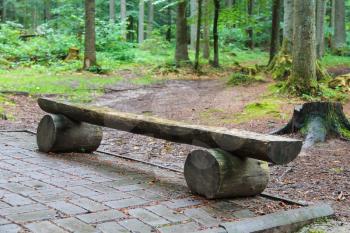 Wooden bench made of tree trunks in city park