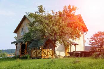 Modern cottage with porch and veranda in sunlight. Carpathians, Ukraine