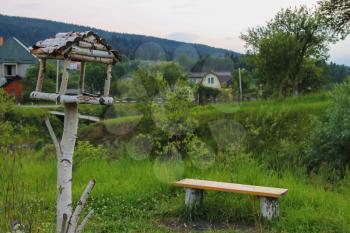Wooden bench and birdhouse in Carpathians, Ukraine