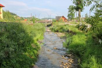 Narrow creek in small town of Carpathians, Ukraine