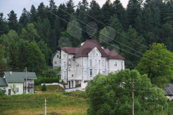 Modern cottages on slope of forested mountains. Carpathians, Ukraine
