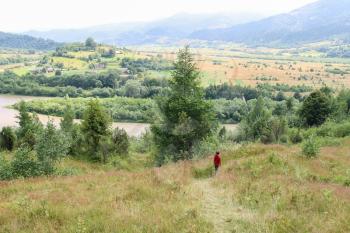 Boy walks picturesque hills of Carpathians. Schodnica, Ukraine