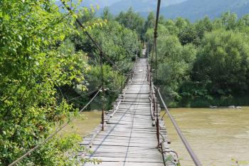 Suspended wooden bridge across Schodnica river in Carpathians, Ukraine