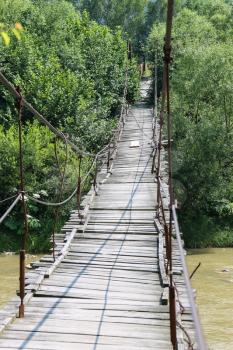 Suspended wooden bridge across Schodnica river in Carpathians, Ukraine