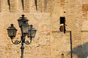 Vintage style lantern before old fortress wall. Spilamberto, Italy