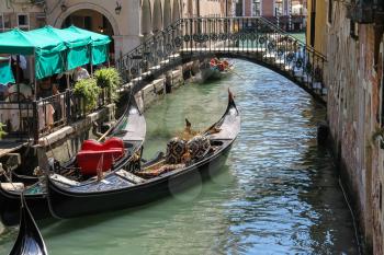 Venice, Italy - August 13, 2016: Empty gondola on canal in city centre