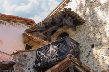 Part of old building with wooden balcony in medieval castle. Grazzano Visconti, Italy