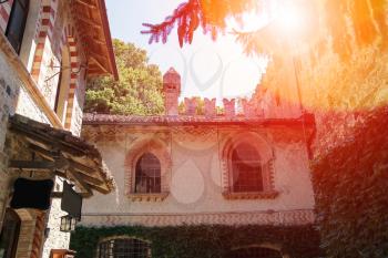 Old buildings in courtyard of ancient castle in sunlight. Grazzano Visconti, Italy
