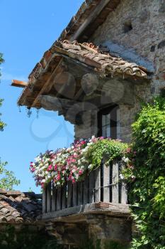 Old building with wooden balcony in medieval Grazzano Visconti, Italy