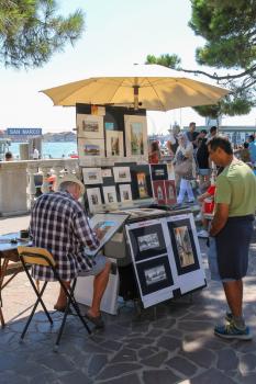 Venice, Italy - August 13, 2016: Street artist and tourists on St. Mark's seafront