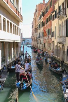 Venice, Italy - August 13, 2016: Tourists in gondolas on canal of Venice