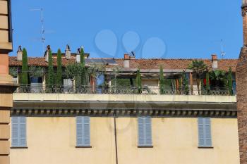 Picturesque old building with trees on terrace in city centre. Piacenza, Italy