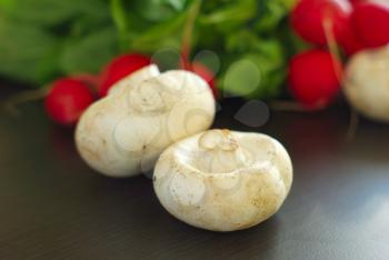 Champignon closeup with red fresh radish background. Organic healthy vegetarian food ingredients. Salad vitamin eating.
