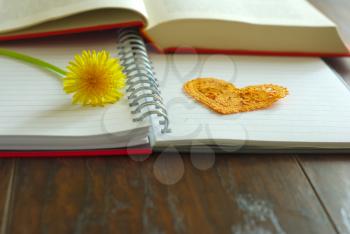 Flower dandelion on notebook with heart symbol Happy Teachers Day celebration image. Yellow flower blossom spring greeting message.