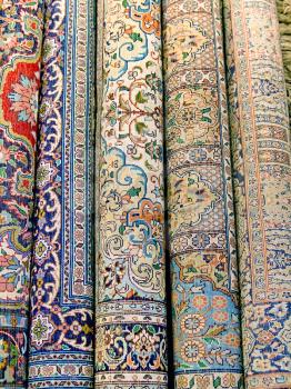 Indian carpets are rolled into rolls as background