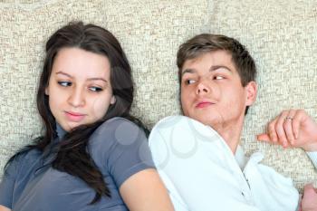 young boy and girl look at each other while lying on bed