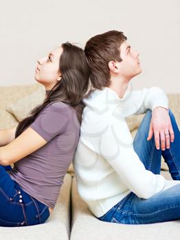 guy and girl sitting back to back on the couch