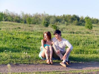 Summer portrait of young couple outdoors. Soft evening sunlight