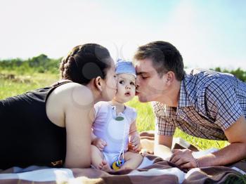 Young parents with baby outdoor in the park