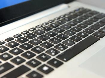 white laptop keyboard with black keys closeup