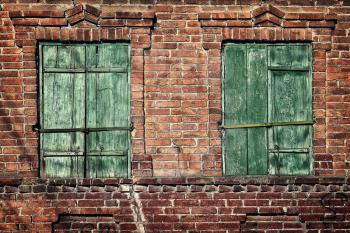 Old window with closed shutters on a brick wall