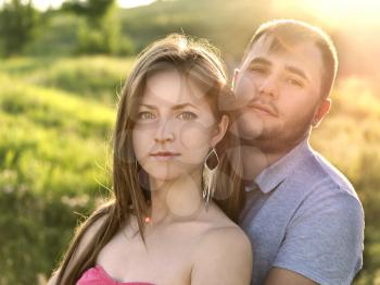 Outdoor summer portrait of pretty nice young family couple in love posing