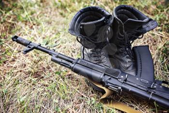 soldier ankle boots and a Kalashnikov assault rifle close-up