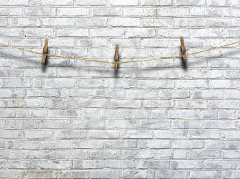 clothesline with clothespins on a background of a brick wall
