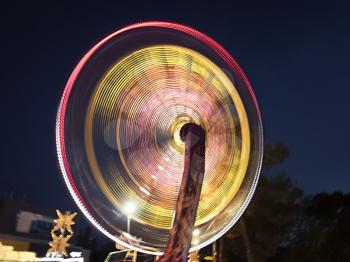 Illuminated rotating carousel in the evening park