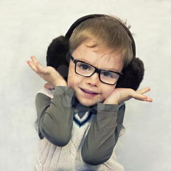 portrait of a little boy in fur headphones