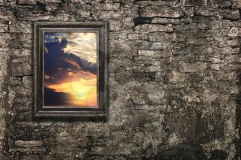 vintage frame on old brick wall as a window with a sunset view