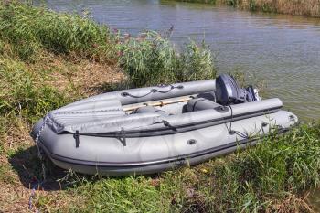 Outboard rubber boat pulled to the riverbank