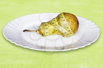 Royalty Free Photo of a Pear in Measuring Tape