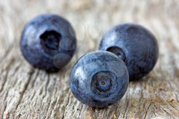three blueberries  on the old wooden background
