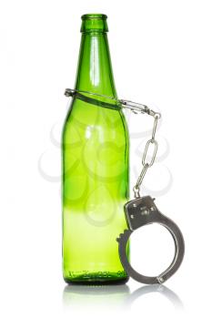 Alcoholism and drunk driving concept. Bottle and handcuffs over a white background