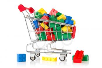 color plastic bricks  in a shopping cart on white background