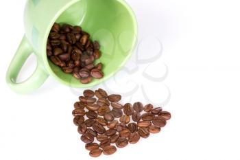Green cup with  coffee beans forming shape of heart