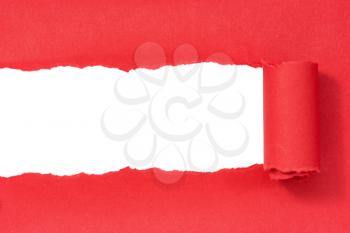 Red paper torn to reveal white panel ideal for copy space