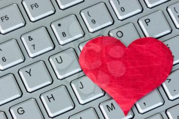 Red heart on the computer keyboard. Internet dating concept