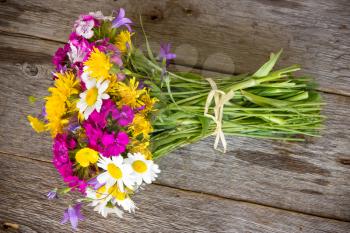 Colorful bouquet of wildflowers on the old wooden floor