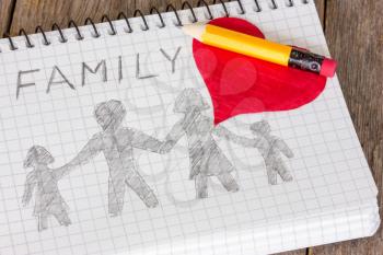 Pencil and heart on the notebook with  drawing of family
