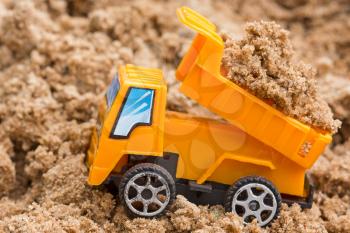 Dump truck unloads soil on the sand at a construction site 