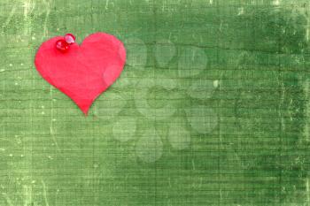 Paper heart pinned to the green wooden wall