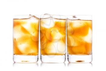 Three shot glass of drink and ice isolated on white 