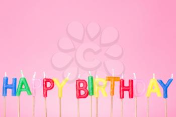 Colorful  Happy birthday candles on the  pink background