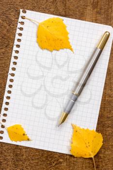  Paper sheet with a pen and autumnal leaves 