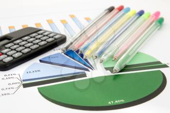 Business chart with a calculator and pile of colored pens